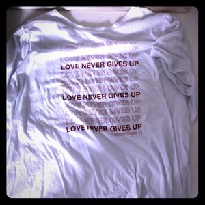 LOVE NEVER GIVES UP TEE